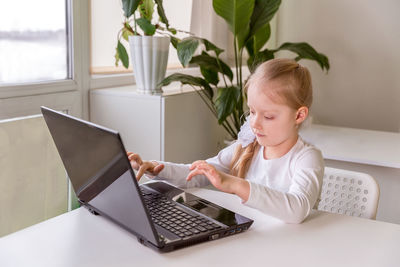 The girl learns communicates, talks through a computer / laptop