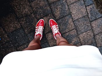 Low section of woman standing on footpath