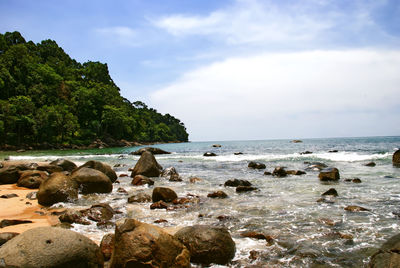 Rocks on beach against sky