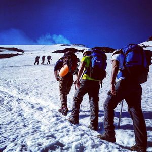 Low angle view of people standing on snow covered landscape