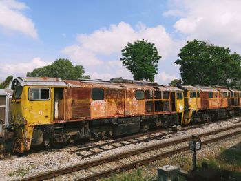 Train by railroad tracks against sky