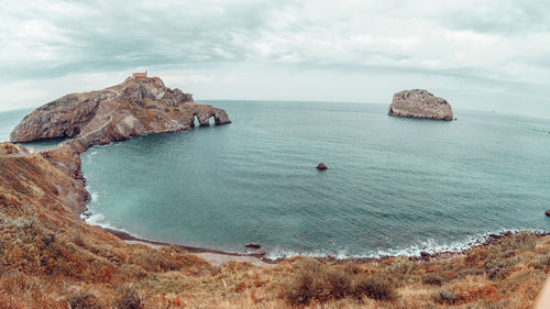 Rocks on sea shore against sky