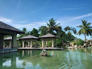 Swimming pool by lake and building against sky