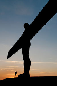 Low angle view of silhouette statue against sky during sunset