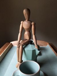 Close-up of wooden mannequin on coffee maker