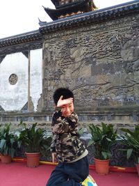 Close-up of woman standing against wall