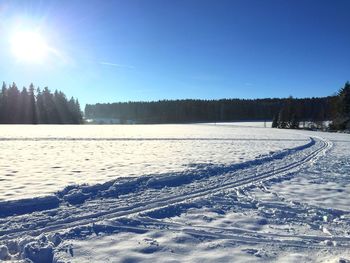 Sun shining over snow covered landscape