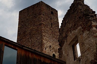 Low angle view of old building against cloudy sky