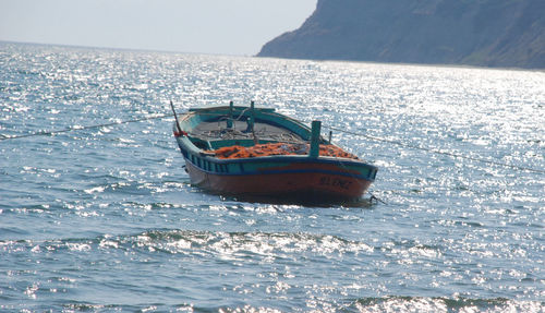 Boat moored in sea against sky