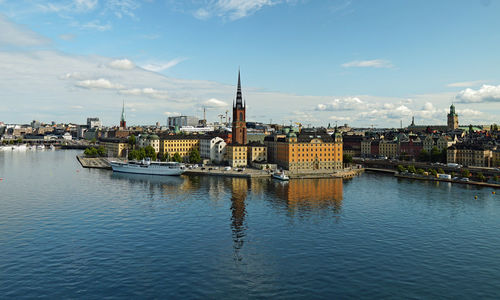 View of buildings at waterfront against cloudy sky