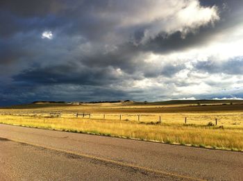 Scenic view of field against cloudy sky