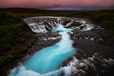 Scenic view of waterfall against sky