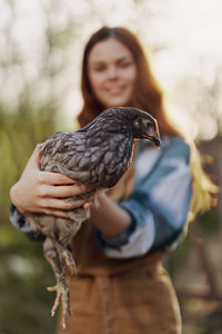 Portrait of woman holding bird feeder