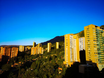 Buildings in city against blue sky