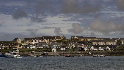 Buildings by sea against sky in city