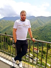 Portrait of man standing by railing