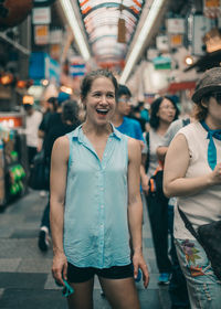 Smiling woman standing on footpath in city