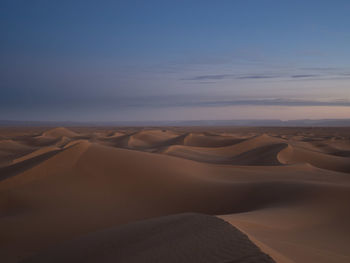 Sand dunes in desert against sky