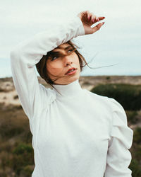 Portrait of beautiful woman standing on land against sky