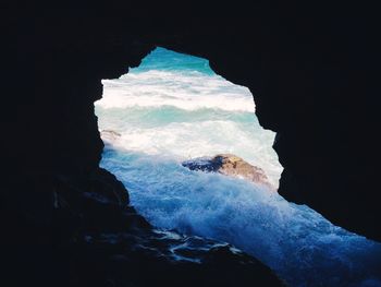 Scenic view of sea seen through cave