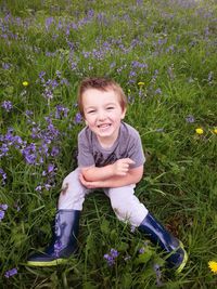 Portrait of boy sitting on grassy field