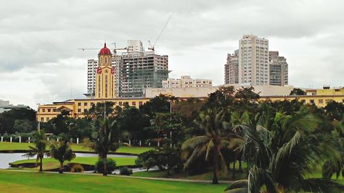 Buildings in city against cloudy sky