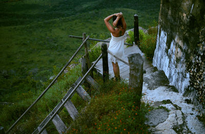 Woman photographing on footbridge