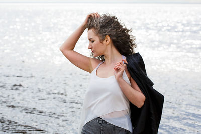 Portrait of a sad curly-haired woman by the sea