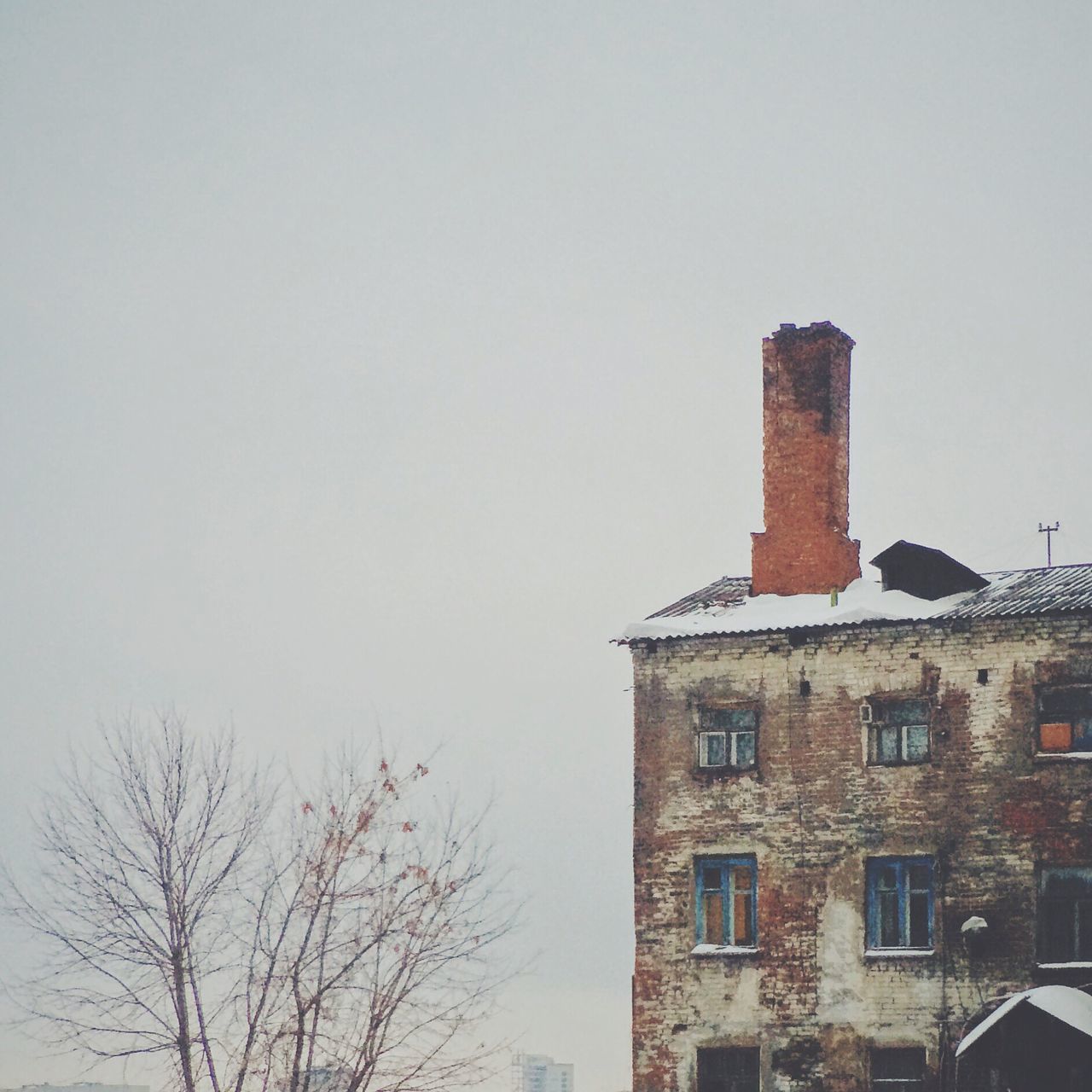 architecture, building exterior, built structure, low angle view, clear sky, bare tree, copy space, tree, tower, building, outdoors, tall - high, sky, day, no people, window, high section, house, residential structure, branch