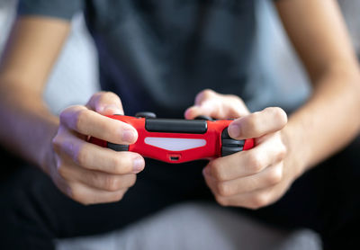 Midsection of man holding game controller