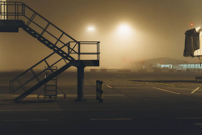 Empty steps against sky at airport runway during night