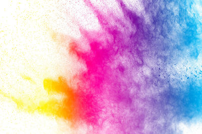 Defocused image of multi colored powder paints against white background