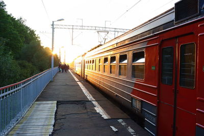 Train on railway bridge against sky during sunset
