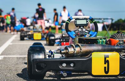 People at car race against sky