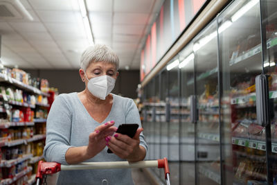 Caucasian elderly woman with white hair shopping in supermarket