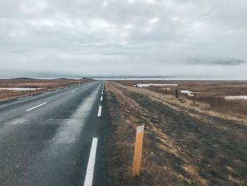 Road passing through land against sky