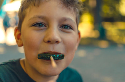 Close-up portrait of boy holding camera