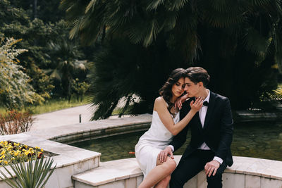 A beautiful couple in love, bride and groom in wedding clothes, walk and pose in the park in nature