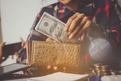 Midsection of man putting money in purse