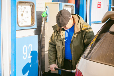 Man filling fuel in car