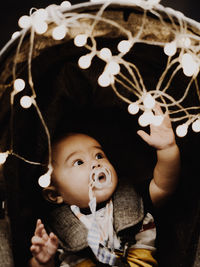 A six months old baby playing with the fairies light attached to the stroller