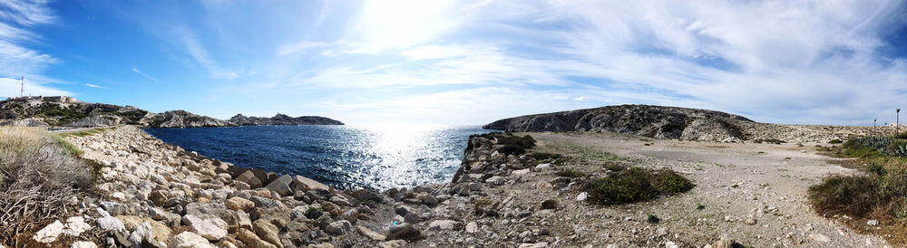 Panoramic shot of rocks on beach against sky