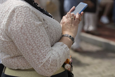 Midsection of woman holding mobile phone