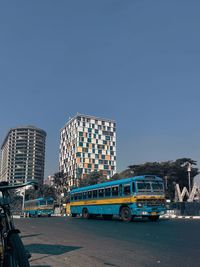 Cars on street against clear blue sky