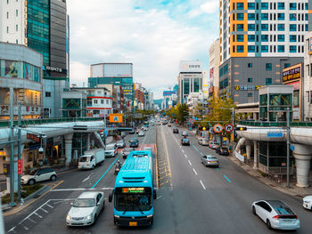 Traffic on city street by buildings against sky