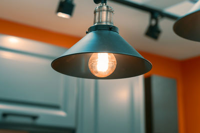 Low angle view of light bulb hanging on ceiling