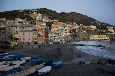 Houses by sea against sky in town