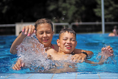 Happy boy and girl swimming in pool