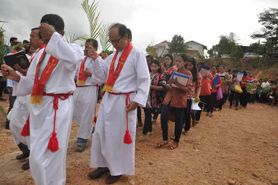 People attending religious mass while walking on field