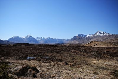 Scenic view of snowcapped mountains against clear blue sky